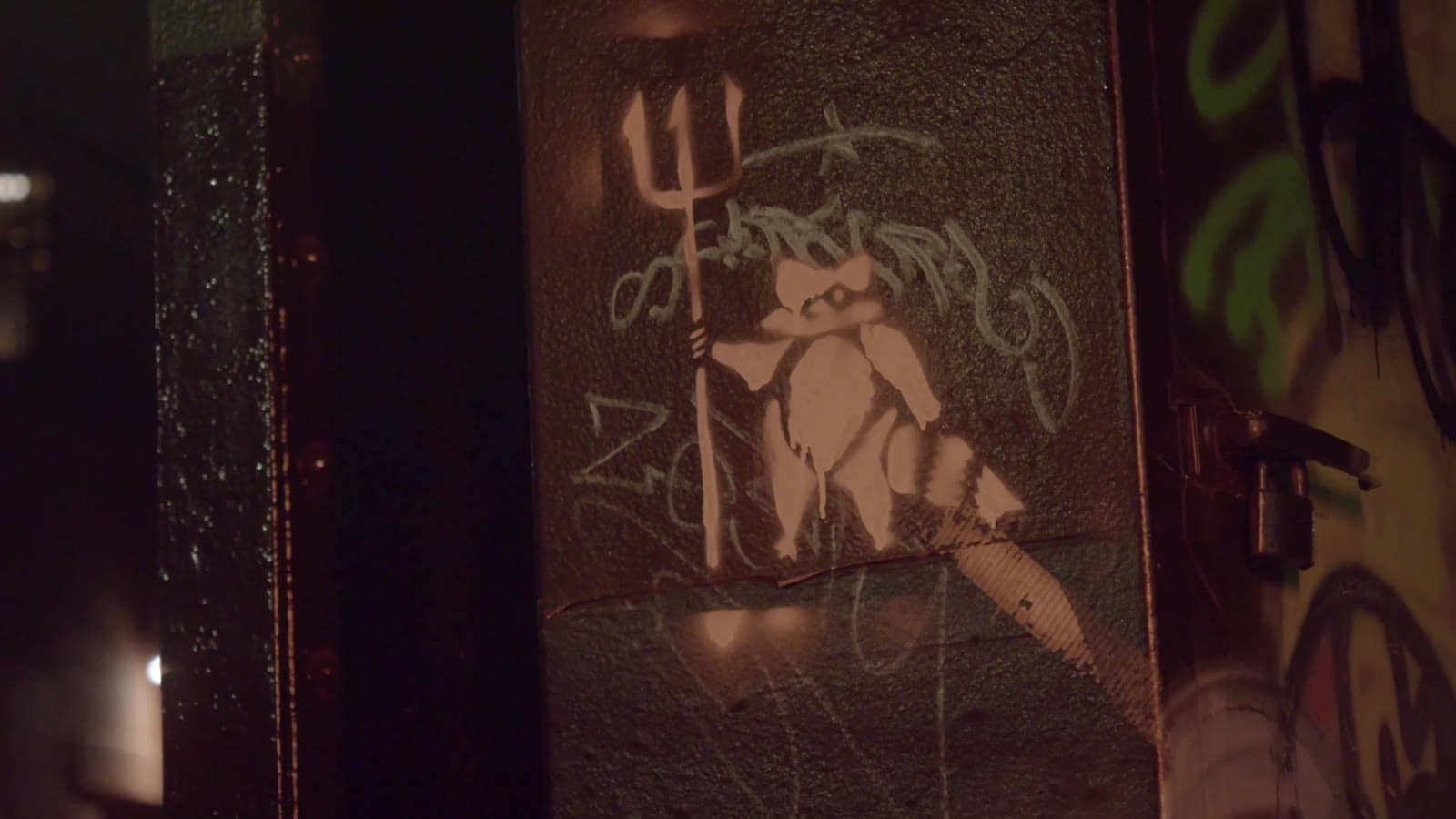 Frame from Cardboard: a stencilled figure on a graffitied door in a dark New York street.
